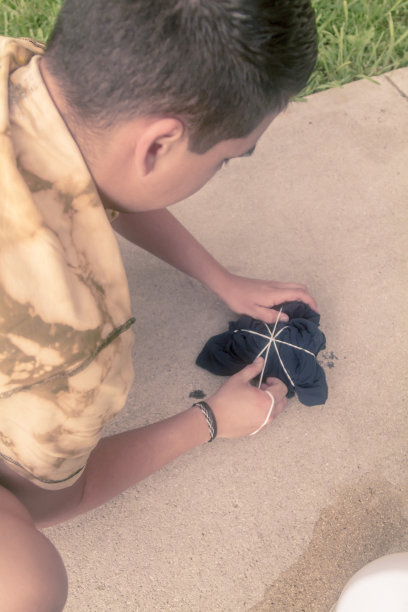 在新冠病毒期间，年轻的拉丁裔男子在美国用扎染工艺制作鲜艳的T恤。图片下载