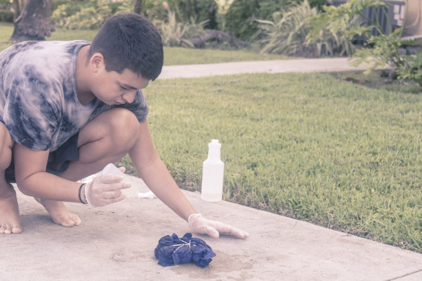 在新冠病毒期间，年轻的拉丁裔男子在美国用扎染工艺制作鲜艳的T恤。图片下载