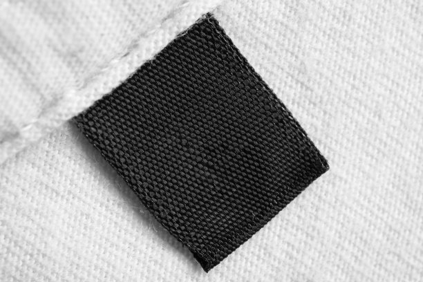 黑色空白洗衣护理衣服标签上白色棉质衬衫背景图片下载