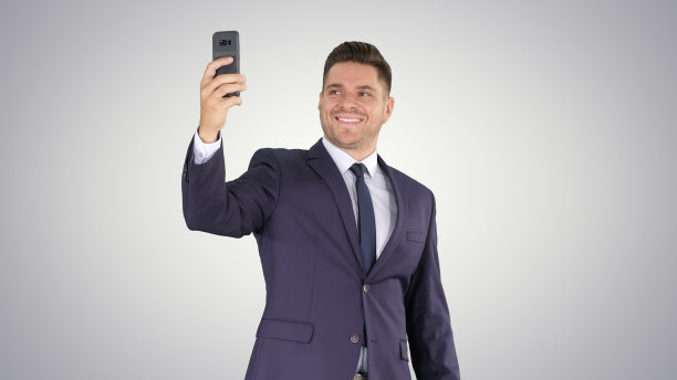 快乐年轻英俊的商人用他的手机录制视频图片下载