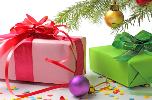 新年礼物放在圣诞树的树枝下，以白色为背景，寓意合家过节。图片下载
