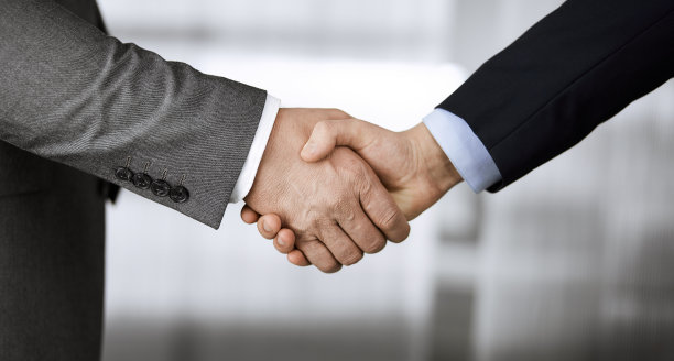 商务人士穿着西装站着握手，特写。商务沟通的概念。握手和营销图片下载
