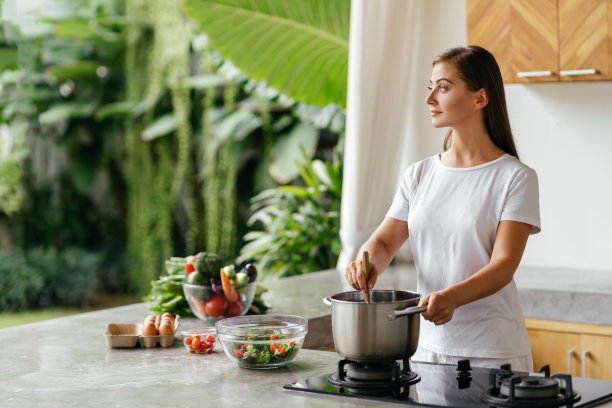漂亮的白人妇女拿着勺子在煮新鲜蔬菜汤的照片图片下载