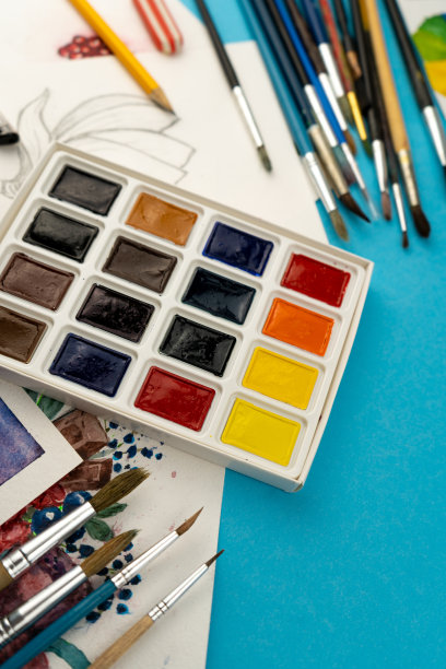 水彩颜料和画笔。艺术家的工作场所和书桌。调色板。蓝色背景。放置你的文本。艺术创造。本空间图片下载