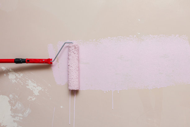 用粉红色的滚筒刷墙素材图片