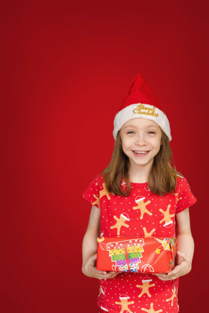 快乐的年轻女孩在圣诞装拿着圣诞礼物图片下载
