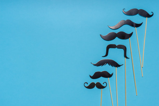 各种黑色的照相亭在蓝色背景上支持不同形状的小胡子。贺卡为父亲节或男性健康意识月的宣传理念。平躺，文字空间，模拟图片下载