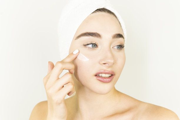 一个笑着的美丽的半裸女人的美丽肖像面霜和看远处孤立的白色背景图片下载