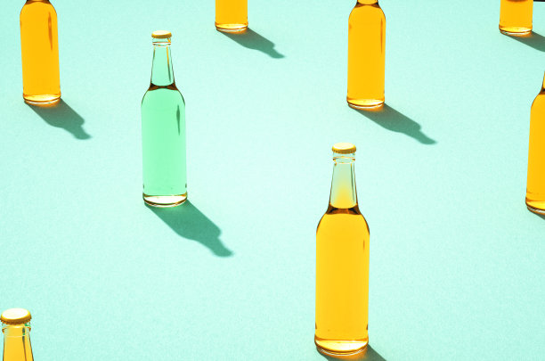 几只淡蓝色背景上有阴影的啤酒瓶。图片下载