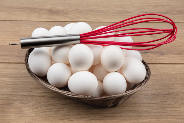 一篮子白色的鸡蛋，用红色的搅拌器做炒鸡蛋图片下载