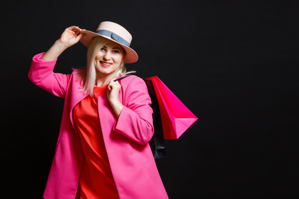 购物的女人拿着包，孤立在黑色的背景。“黑色星期五”的概念图片下载