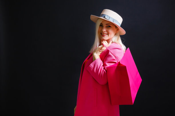 购物的女人拿着包，孤立在黑色的背景。“黑色星期五”的概念图片下载