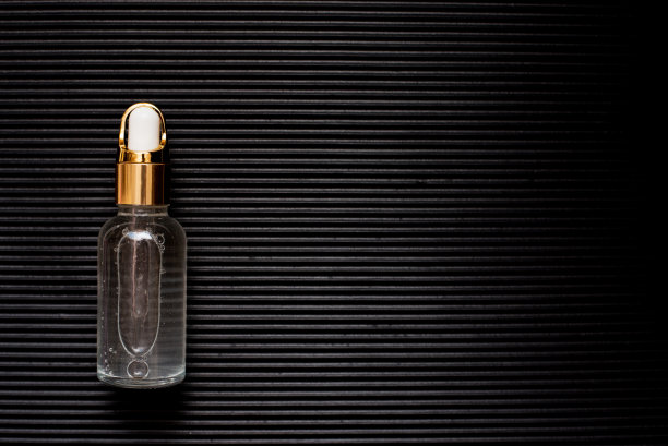 化妆油的瓶子上有纹理的黑色背景图片下载