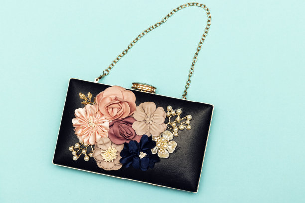 美丽的女人花黑色手包在蓝色的背景图片下载