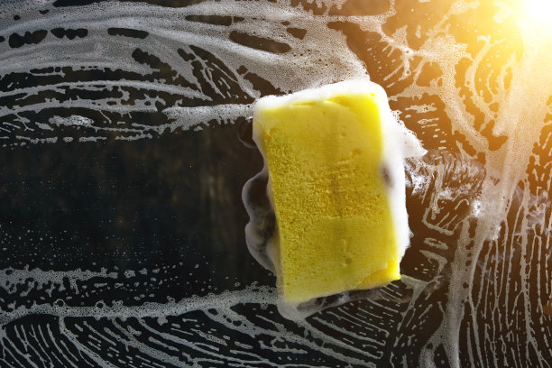 手拿黑色手套，用泡沫海绵清洗玻璃，用泡沫海绵在深色背景上，用浅色擦。图片下载