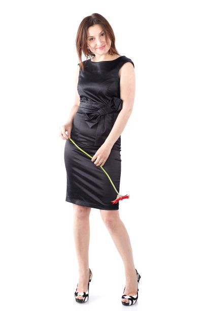 全长女性模特在白色背景上的工作室照明黑色连衣裙。美丽的年轻女子穿着黑色连衣裙与非洲菊花，全身图片下载