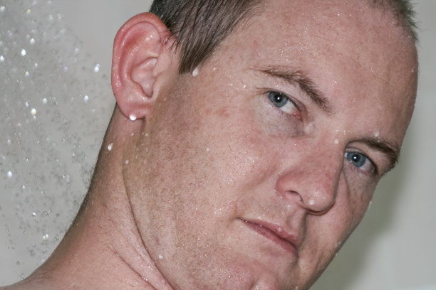 在淋浴中站立的白人男人图片下载