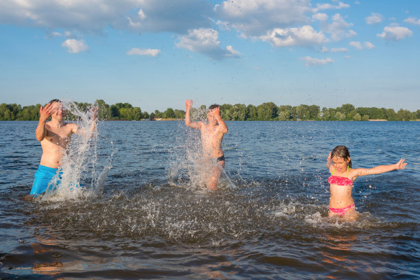 幸福的家庭泼水，玩得开心。家庭暑假和水上活动的孩子。图片下载