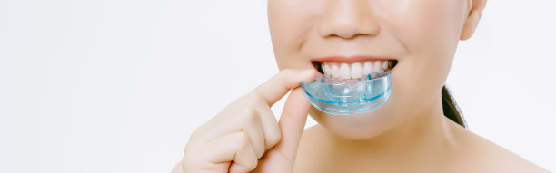全景横幅图像，网页或封面模板的年轻亚洲妇女穿着正畸硅胶训练器。Invisalign正畸治疗的概念。横幅全景。广泛的作物图片下载