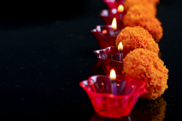 印度排灯节，万寿菊花和彩色油灯在黑色的背景图片下载