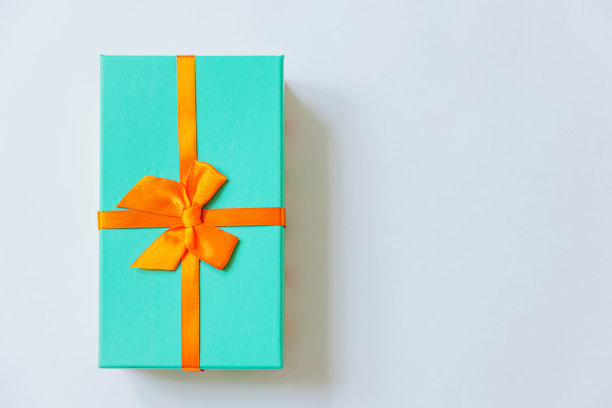 圣诞节，新年，生日，情人节庆祝礼物浪漫的概念。简单的最小设计的蓝色礼盒与橙色丝带孤立的白色背景。平放俯视图拷贝空间图片下载
