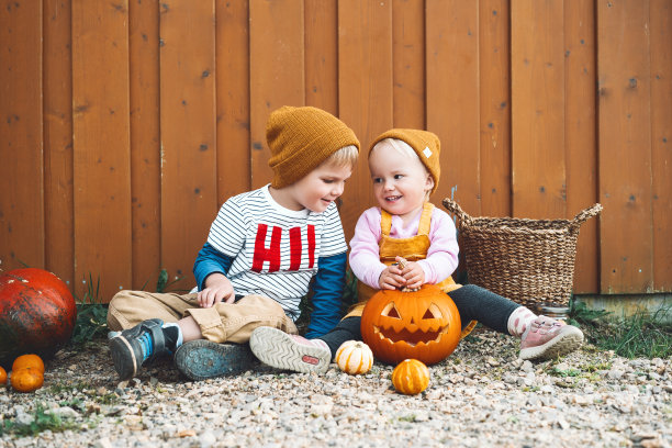 万圣节快乐!照片的秋天心情与时尚的女孩和男孩在农村玩。图片下载