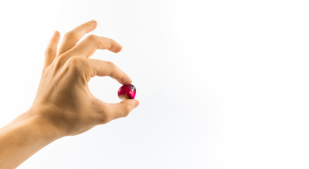 珍贵的红石在判断手在白色孤立的背景横幅照片图片下载