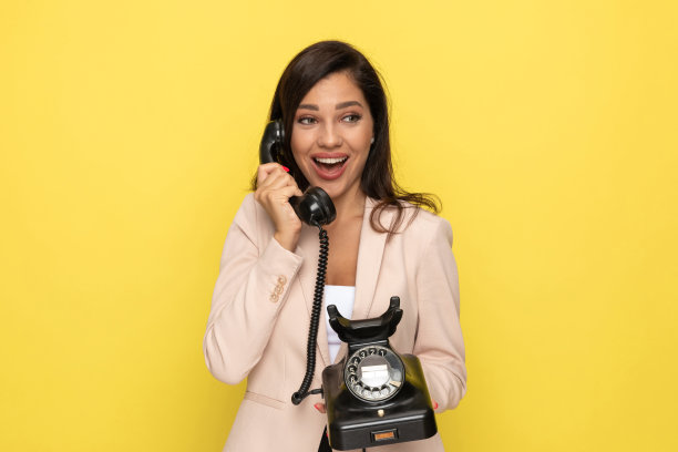 热情的年轻女孩在旧的旋转电话上交谈图片下载