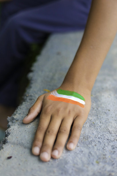 印度孩子的手上和手腕上戴着印度国旗图片下载