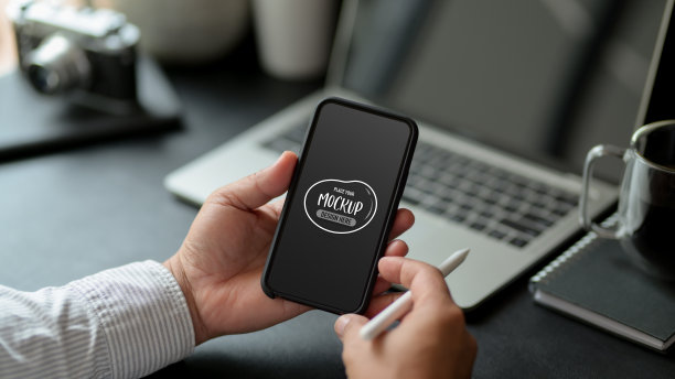 坐在工作桌前使用模拟智能手机的男性图片下载