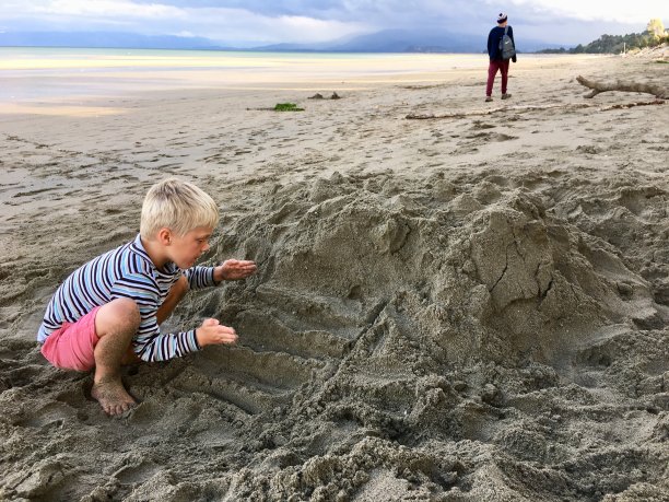 冬天，孩子们在沙滩上把楼梯雕刻成沙子图片下载