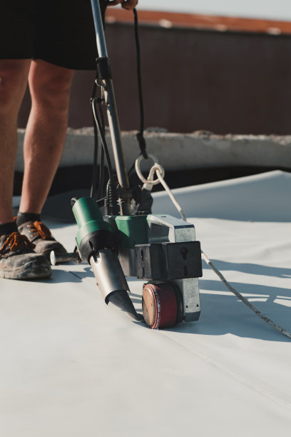 工人用焊接机加热焊接PVC屋顶膜图片下载