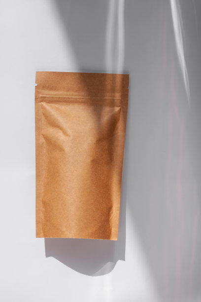 棕色牛皮纸纸袋与咖啡豆顶视图与阴影孤立在白色背景。食品包装平铺图片下载