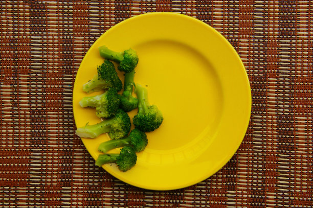 煮熟的西兰花。黄色的盘子里放着绿色的西兰花图片下载