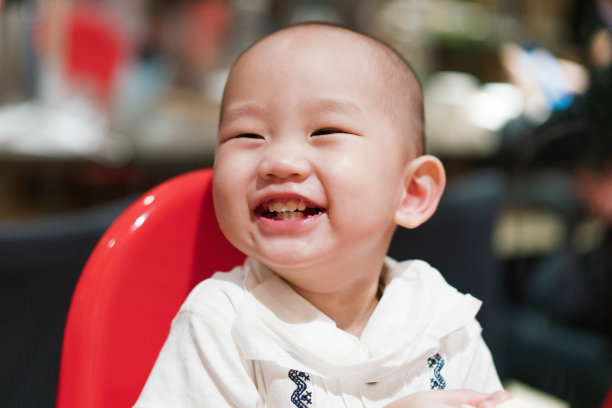 一个小男孩坐在餐厅的餐椅上图片下载