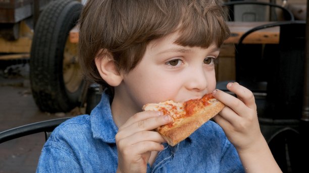 一个小男孩在吃披萨图片下载