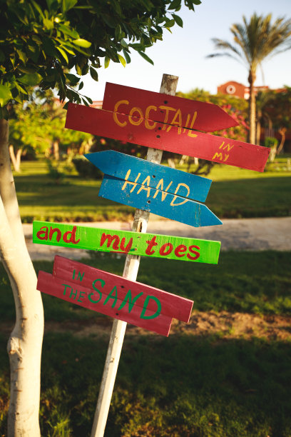 手握鸡尾酒，脚踩沙滩标牌图片下载