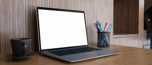 老式的工作空间，笔记本电脑空白屏幕，咖啡杯，文具放在木桌上。图片下载