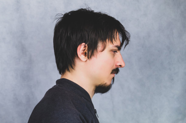 灰色背景上年轻男子的侧面图图片下载