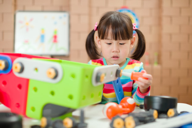 年轻女孩玩创造性玩具积木在家上学图片下载