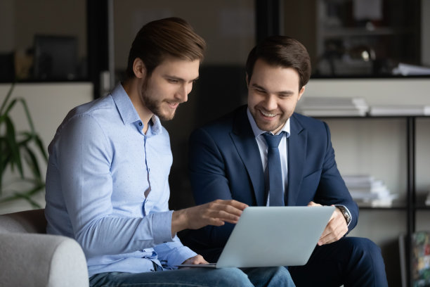 两个微笑的商人讨论良好的项目成果。图片下载