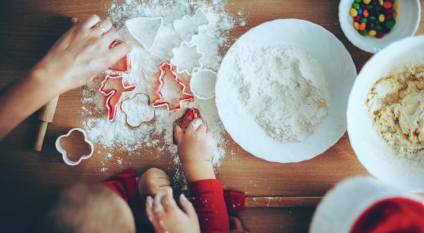 上面的照片，一个白人家庭在家里用面粉和表格一起烹饪圣诞节甜饼干图片下载
