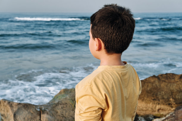 孩子看向海边的岩石图片下载
