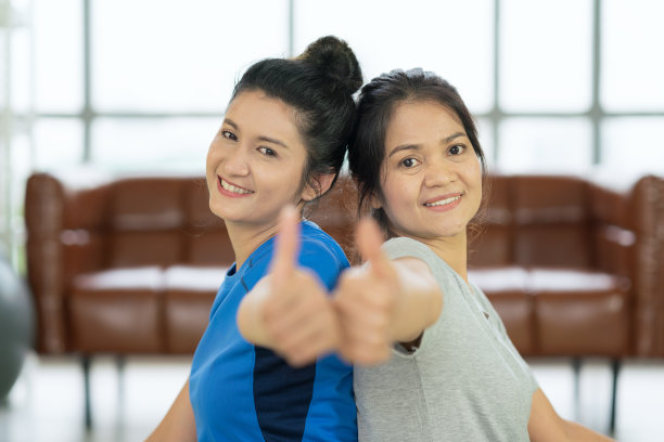 亚洲美女坐在瑜伽垫与fitball和感觉脚踝疼痛图片下载