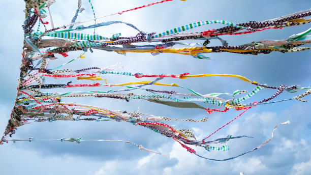 在多云的天空背景下，五颜六色的彩带在风中飘扬图片下载