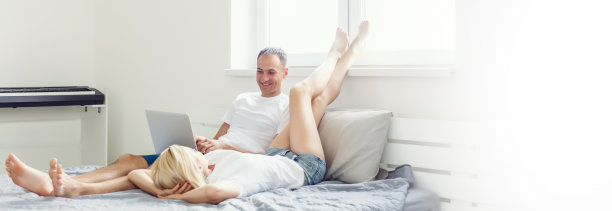 幸福的夫妇在床上放松，早上手牵着手图片下载