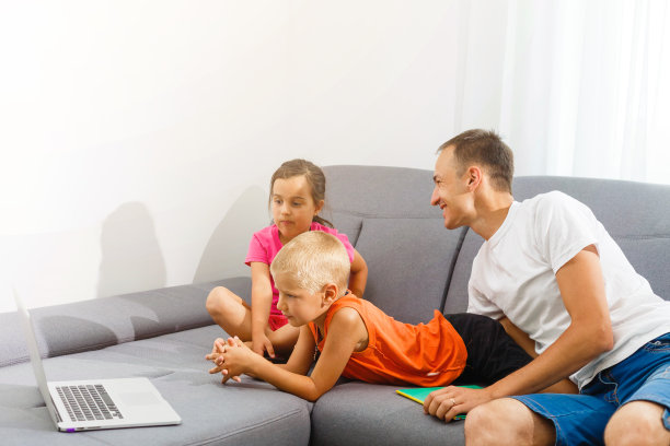 孩子和他们的父亲使用笔记本电脑，在家里在线学习图片下载
