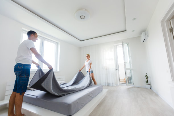 一对夫妇在铺床图片下载