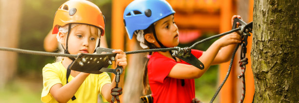 一个可爱的小女孩在一个冒险的绳索公园的索桥上散步的肖像。图片下载