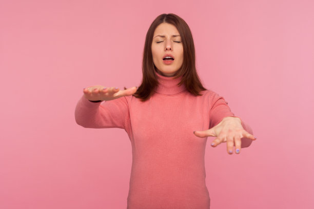 有视力问题的褐发女人试图闭着眼睛移动用手触摸周围的空间，视力障碍图片下载